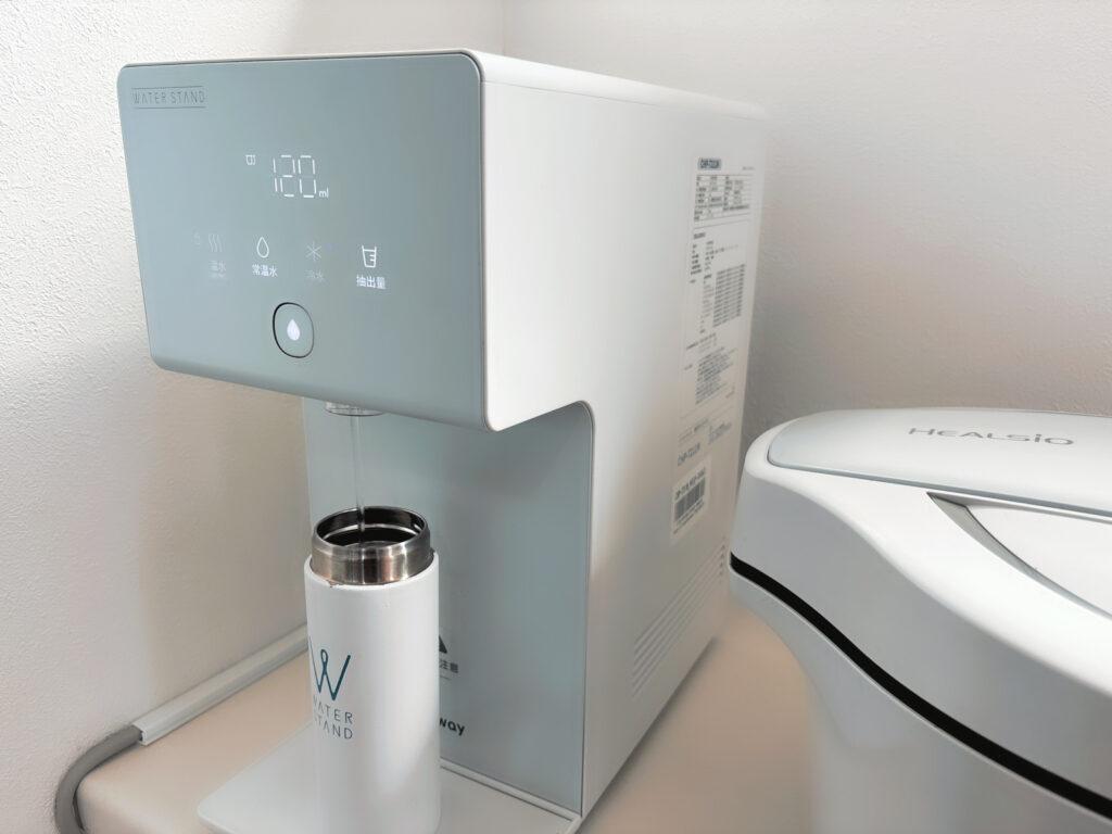 ウォータースタンド アイコンから水筒に自動で水が注がれている画像
