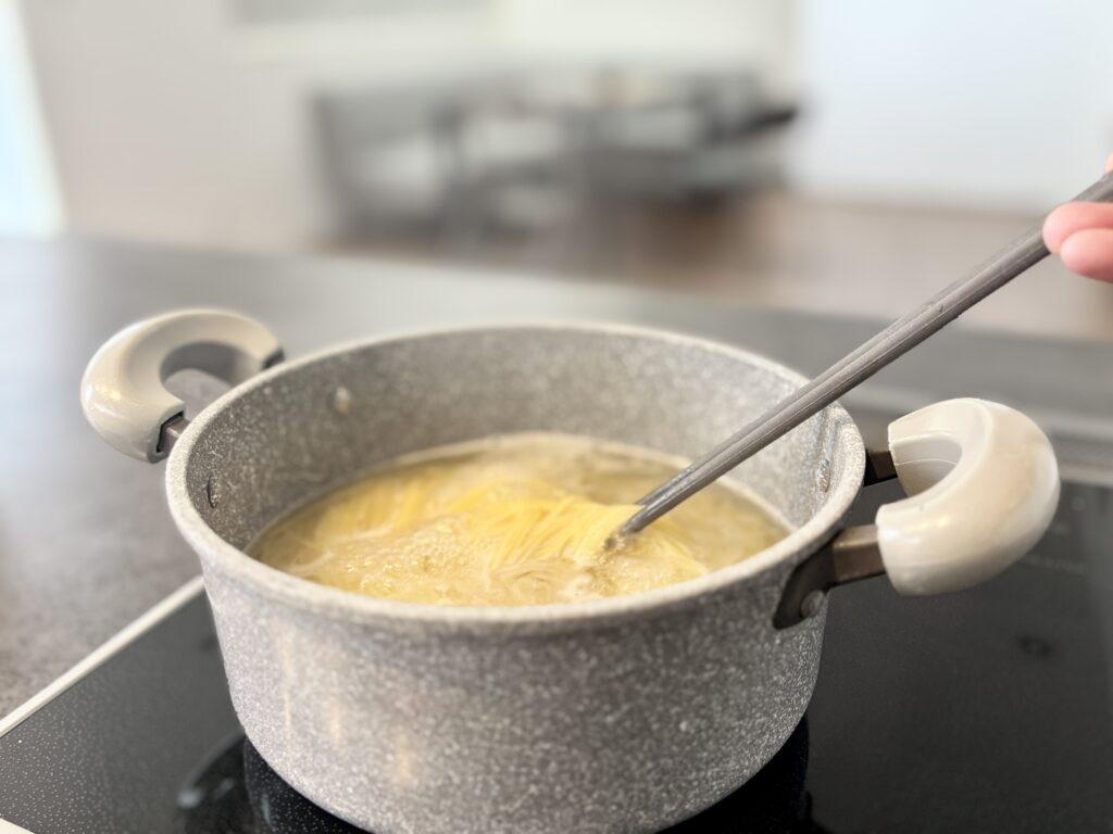 ウォータースタンドでパスタの麺をゆでている画像